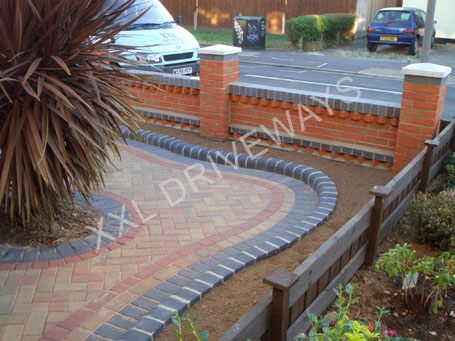 Block paved driveway, patio rear garden, brick front garden wall with flower bed.